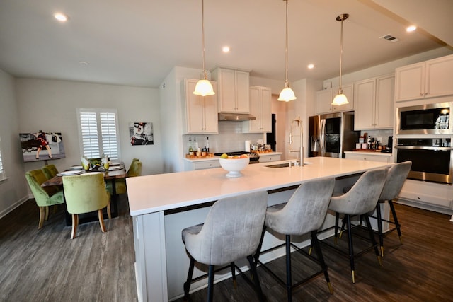 kitchen featuring visible vents, appliances with stainless steel finishes, decorative backsplash, and a sink