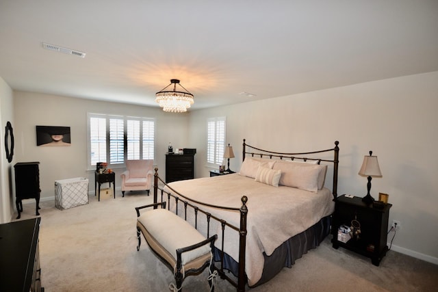 bedroom with visible vents, baseboards, light colored carpet, and a chandelier