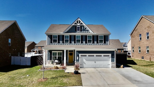 view of front facade featuring an attached garage, a porch, concrete driveway, and a front yard