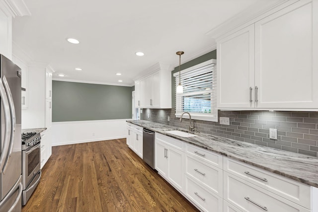 kitchen with ornamental molding, a sink, dark wood-style floors, white cabinetry, and appliances with stainless steel finishes