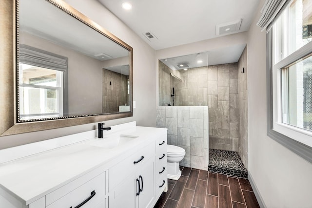 full bath featuring visible vents, plenty of natural light, a walk in shower, and wood finish floors