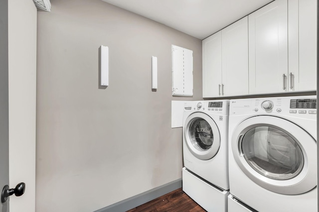 clothes washing area with baseboards, cabinet space, dark wood-style flooring, and washer and clothes dryer