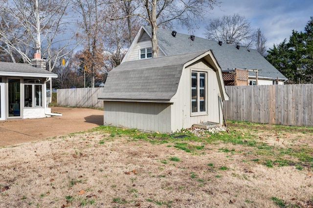 view of shed featuring a fenced backyard and a sunroom