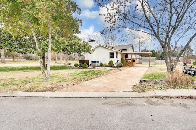 view of front of property featuring a carport, stucco siding, driveway, and a front yard