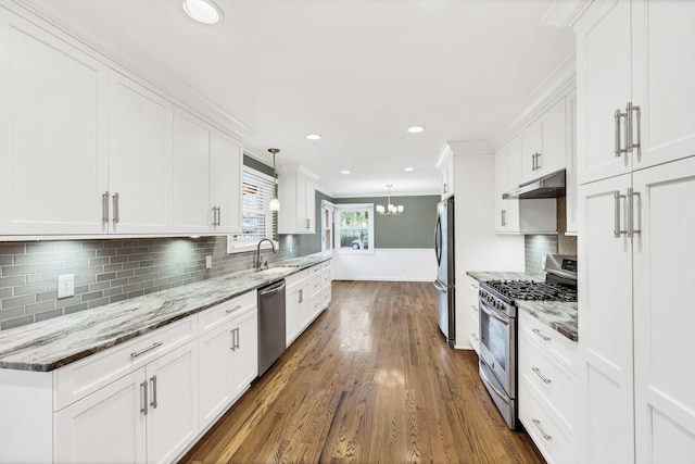 kitchen featuring crown molding, under cabinet range hood, white cabinets, stainless steel appliances, and dark wood-style flooring