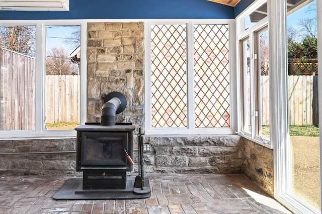 room details featuring a wall unit AC and a wood stove