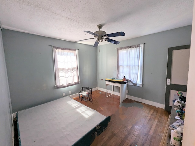 interior space featuring a textured ceiling, baseboards, and wood finished floors