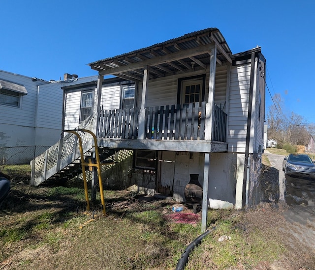 rear view of property featuring stairs and a porch