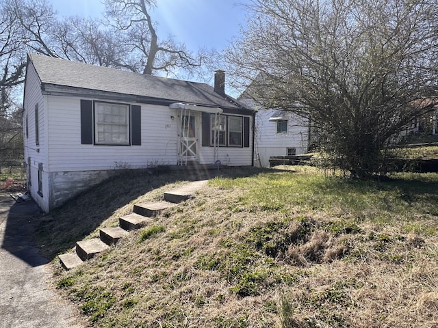 view of front of property with a chimney and a shingled roof