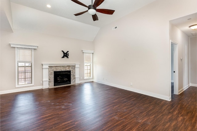 unfurnished living room with dark wood-type flooring, a ceiling fan, a fireplace, baseboards, and vaulted ceiling