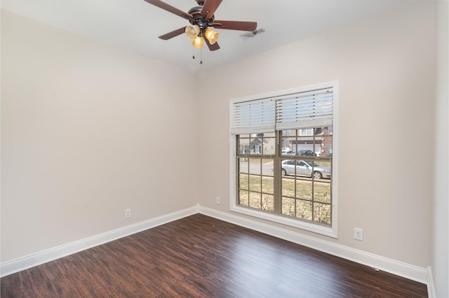 spare room with visible vents, dark wood-type flooring, and baseboards