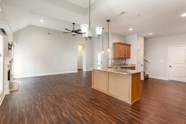 kitchen featuring visible vents, a fireplace with raised hearth, a peninsula, and dark wood-type flooring