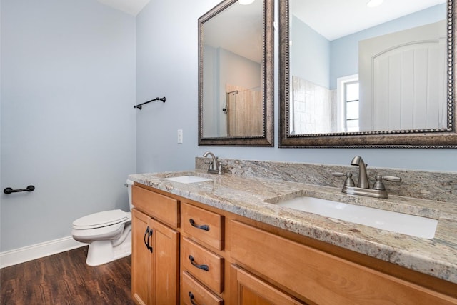 full bathroom featuring wood finished floors, toilet, baseboards, and a sink