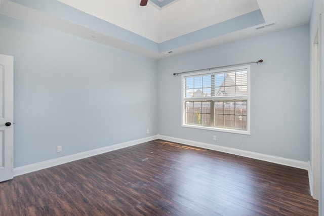 unfurnished room featuring wood finished floors, visible vents, and baseboards