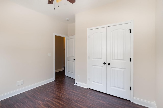 unfurnished bedroom with a closet, baseboards, dark wood-style floors, and a ceiling fan