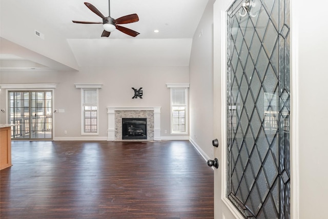 unfurnished living room with visible vents, a fireplace with flush hearth, a ceiling fan, dark wood finished floors, and baseboards