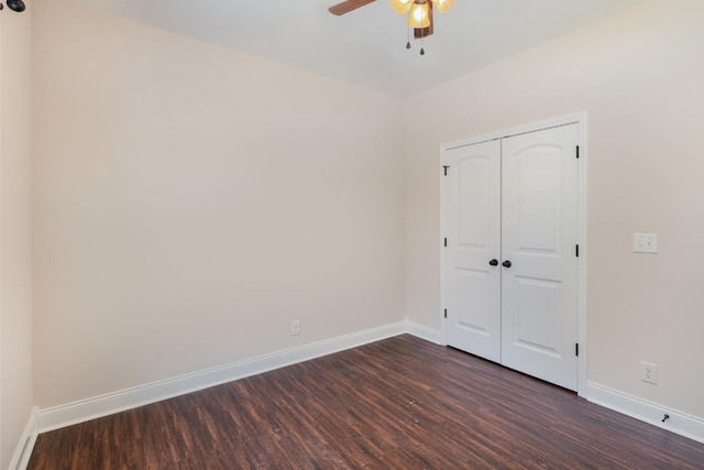 unfurnished bedroom featuring a closet, a ceiling fan, baseboards, and dark wood-style flooring