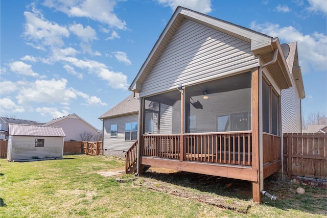 rear view of house featuring a shed, a yard, a fenced backyard, a sunroom, and an outdoor structure