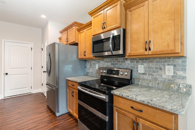 kitchen with backsplash, appliances with stainless steel finishes, brown cabinetry, light stone countertops, and dark wood-style flooring