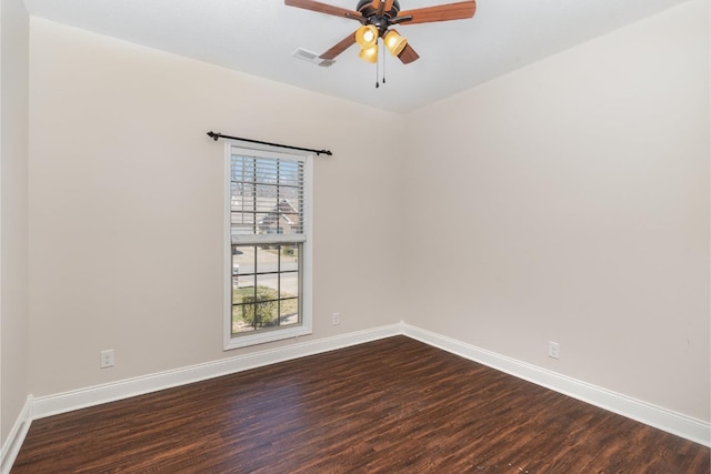 spare room with dark wood finished floors, baseboards, visible vents, and ceiling fan