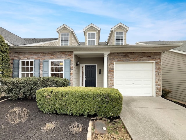 view of front of property with an attached garage, stone siding, driveway, and roof with shingles