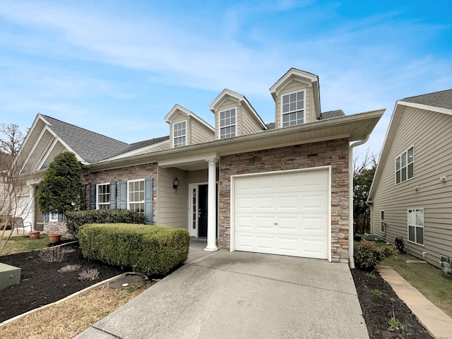 view of front facade featuring concrete driveway, a garage, stone siding, and roof with shingles