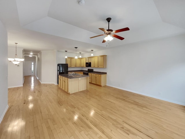 kitchen featuring dark countertops, open floor plan, black appliances, and light wood-style floors