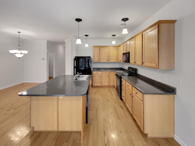 kitchen featuring black appliances, light brown cabinetry, a sink, dark countertops, and light wood-style floors