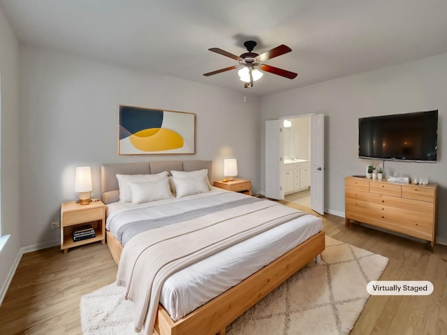 bedroom featuring connected bathroom, a ceiling fan, baseboards, and wood finished floors