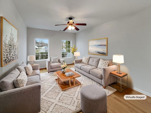 living area with baseboards, ceiling fan, and wood finished floors