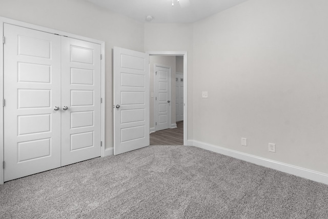 unfurnished bedroom featuring a closet, carpet flooring, ceiling fan, and baseboards