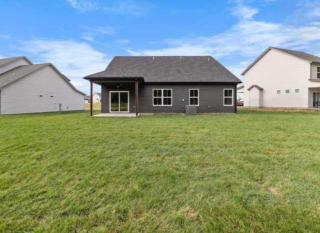 back of house with a patio, cooling unit, a lawn, and a shingled roof