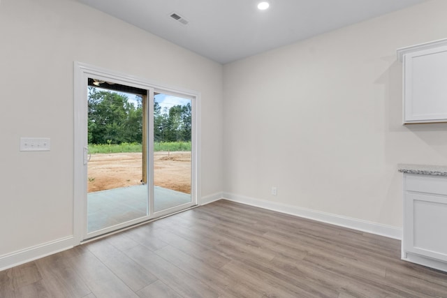 interior space with visible vents, light wood-style flooring, and baseboards