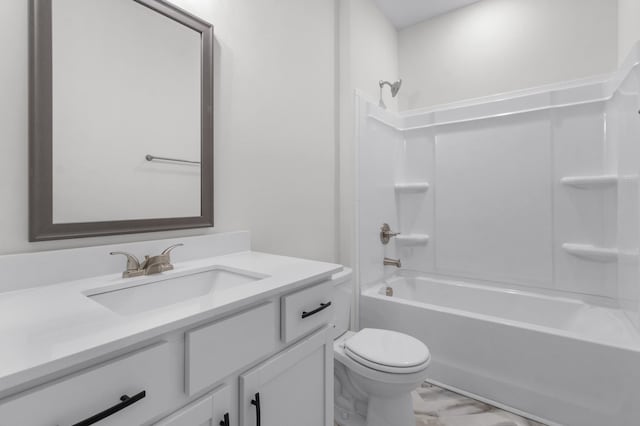 bathroom featuring marble finish floor, toilet, vanity, and  shower combination