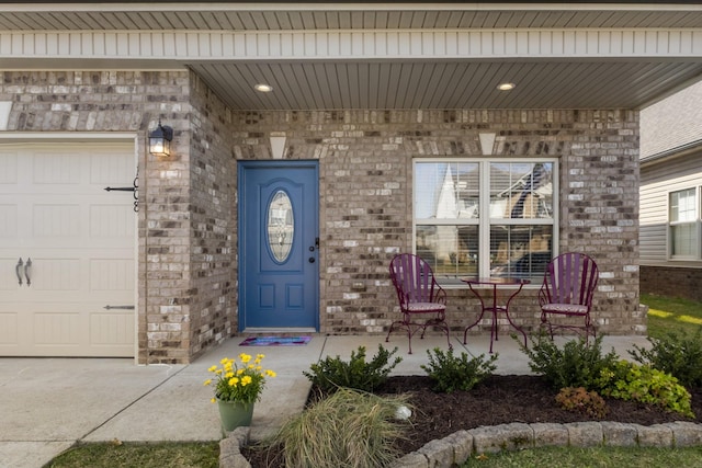 doorway to property with brick siding and a garage