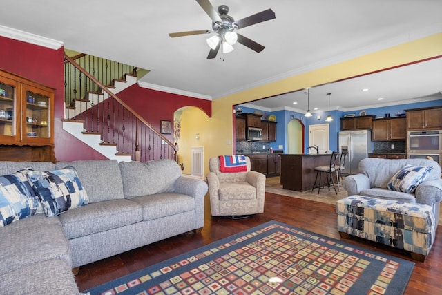 living room featuring dark wood-type flooring, recessed lighting, stairway, arched walkways, and ceiling fan