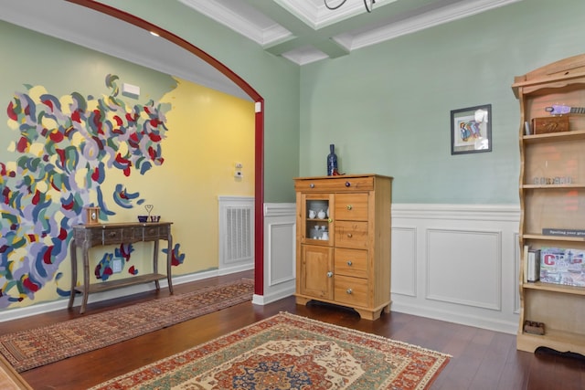 interior space featuring hardwood / wood-style floors, a wainscoted wall, visible vents, coffered ceiling, and crown molding