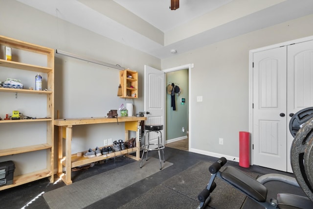 workout area featuring ceiling fan and baseboards