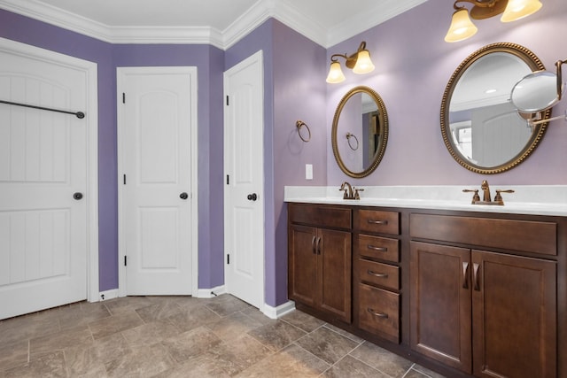 bathroom with a sink, baseboards, double vanity, and crown molding