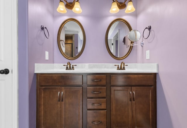 bathroom with a sink, a chandelier, and double vanity