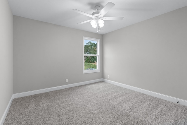 carpeted empty room with a ceiling fan and baseboards