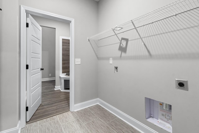 washroom with laundry area, hookup for a washing machine, hookup for an electric dryer, and baseboards