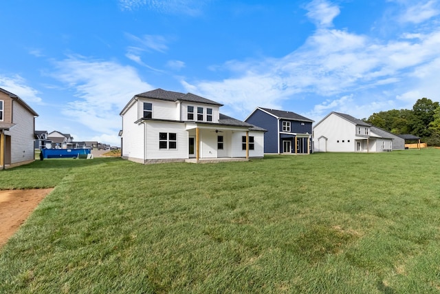 rear view of property with a yard and a patio area