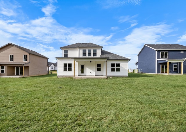 rear view of house featuring a yard, roof with shingles, a ceiling fan, and a patio area