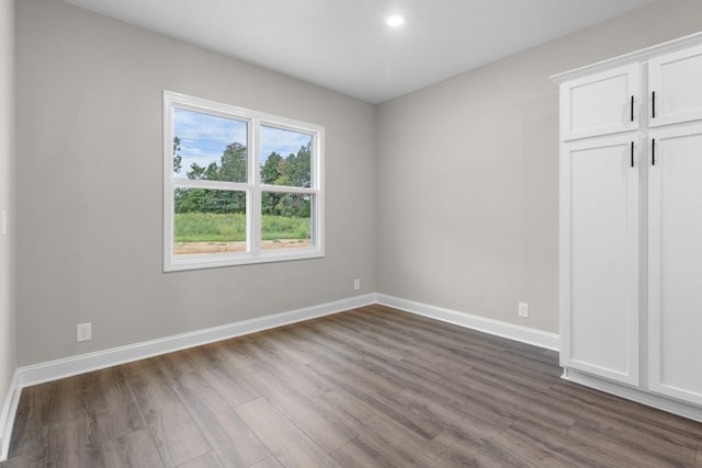 unfurnished bedroom with dark wood finished floors, recessed lighting, a closet, and baseboards