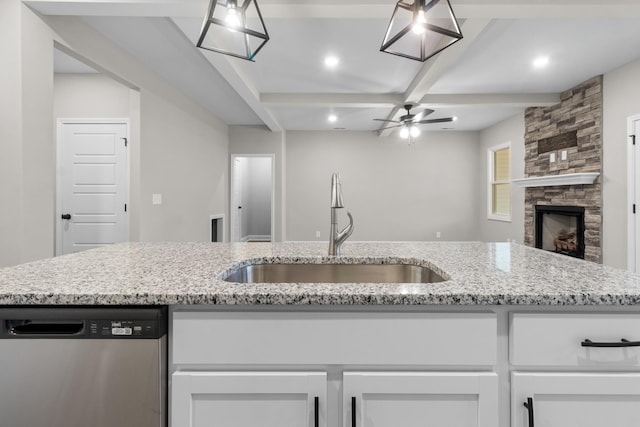 kitchen featuring white cabinetry, beam ceiling, a sink, dishwasher, and open floor plan