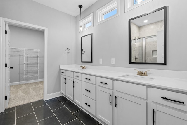 full bathroom with a sink, a stall shower, double vanity, and tile patterned floors