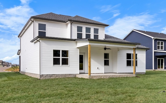 view of front facade with a patio area, a front lawn, a ceiling fan, and a shingled roof