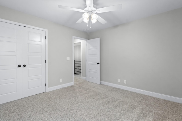 unfurnished bedroom featuring carpet flooring, baseboards, a closet, and ceiling fan