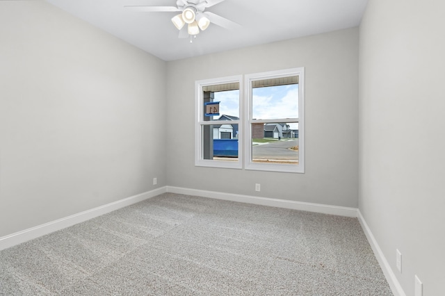 carpeted spare room with baseboards and ceiling fan